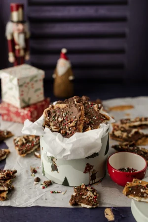 Tło fotograficzne Autumn Grapes które znajduje się w kadrze jako tło tylne. Stylizacja przestawia pudełko słodkości w klimacie świątecznym, Drobne kawałki pokruszone w koło pudełka a dodatkowe elementy w postaci foigurek nadają zdjęciu jeszcze bardziej świątecznewgo klimatu.