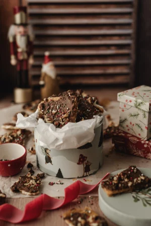 Tło fotograficzne Autumn Pantry, które znajduje się w kadrze jako tło tylne. Stylizacja przestawia pudełko słodkości w klimacie świątecznym, Drobne kawałki pokruszone w koło pudełka a dodatkowe elementy w postaci foigurek nadają zdjęciu jeszcze bardziej świątecznewgo klimatu.