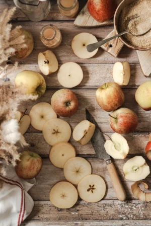 Tło do fotografii kulinarnej i produktowej Rustic Door jest to rustykalne, postarzane drewniane tło fotograficzne w odcieniach beżu i brązu z jabłkami, plasterkami jabłek, nożem i naturalnymi dodatkami – klimatyczne tło do fotografii kulinarnej, jesiennych stylizacji, zdjęć produktowych typu flat lay w stylu vintage i farmhouse.